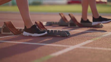 En-Las-Competiciones-En-La-Colina,-Una-Mujer-Pone-Sus-Manos-En-La-Línea-De-Salida-En-Primer-Plano.-La-Carrera-Comenzó.-Preparación-En-Cámara-Lenta-De-La-Carrera-A-La-Mujer-En-El-Estadio.